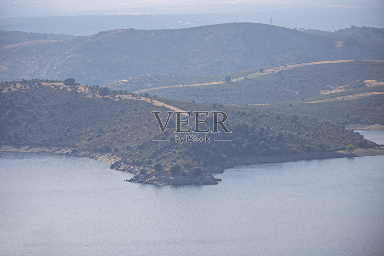 长焦全景照片，视觉上压缩了水库后面的山峦，形成了蓝色和绿色的层次感照片摄影图片