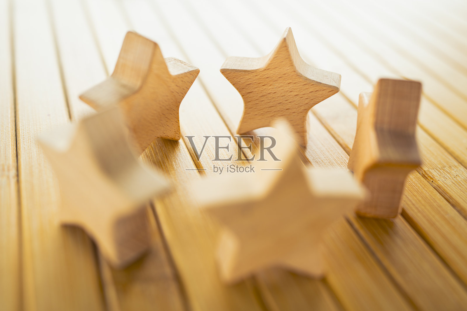 木制星星摆放在桌上，象征着客户评价、产品评论、服务质量评估、满意度衡量、业务反馈和品牌声誉的概念。照片摄影图片