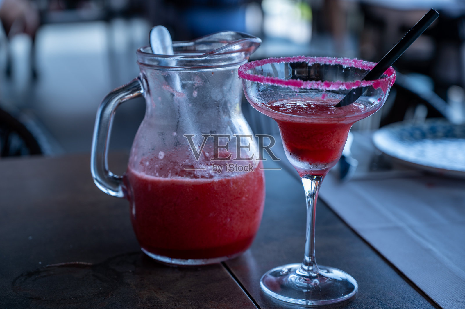 罐装的玛格丽特酒，配有玻璃杯和黑色吸管。照片摄影图片