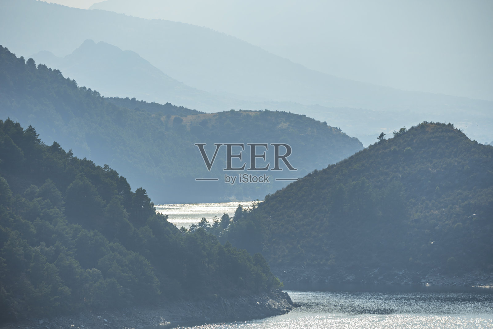 夏日日出，低雾在阳光的温暖下逐渐消散于水库之上，山峰初露照片摄影图片