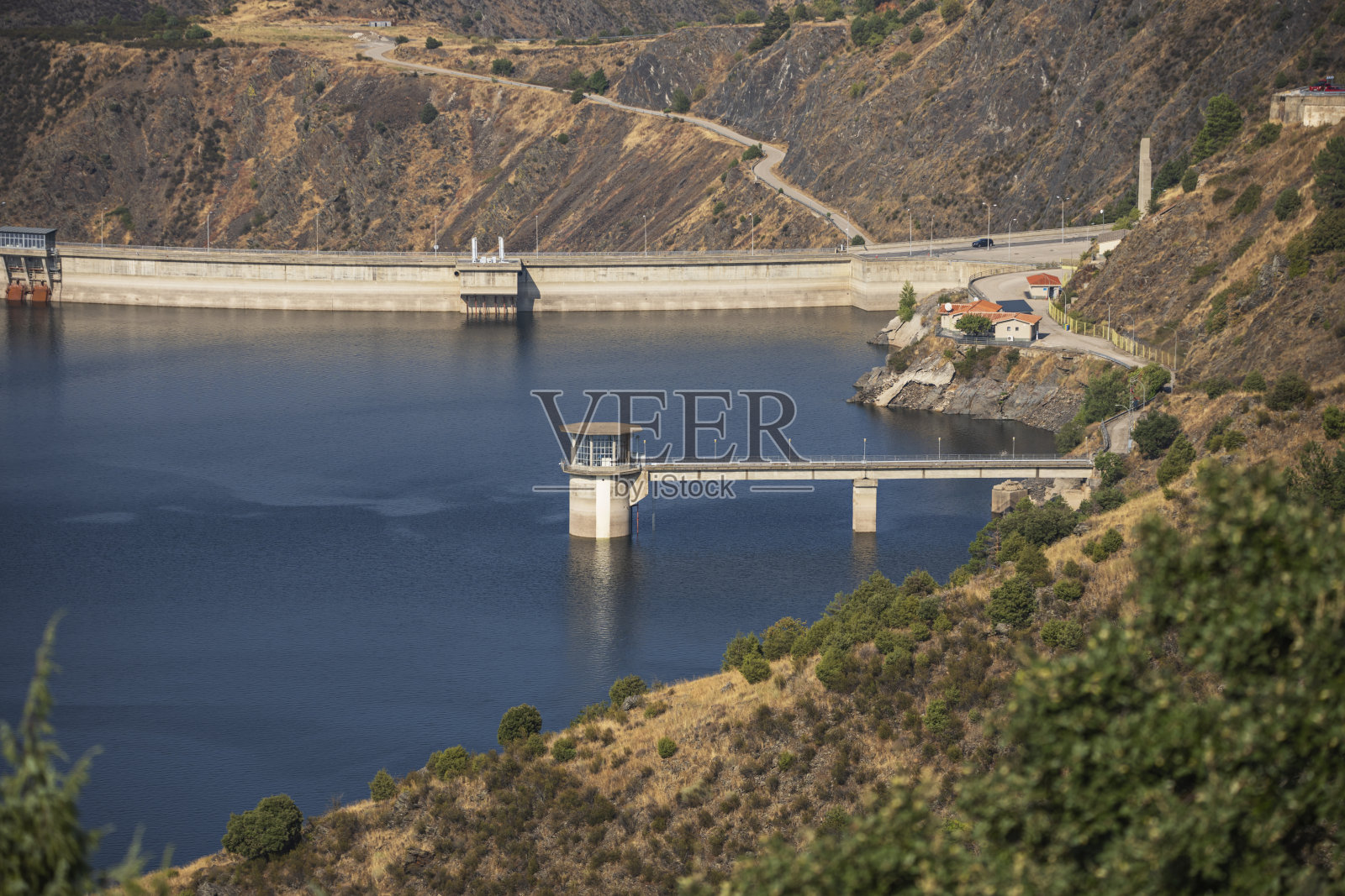秋季水库，落叶乔木金红色的树叶倒映在平静的深色水中照片摄影图片