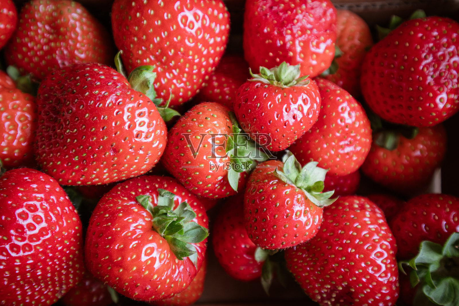 一堆新鲜草莓带着绿叶照片摄影图片