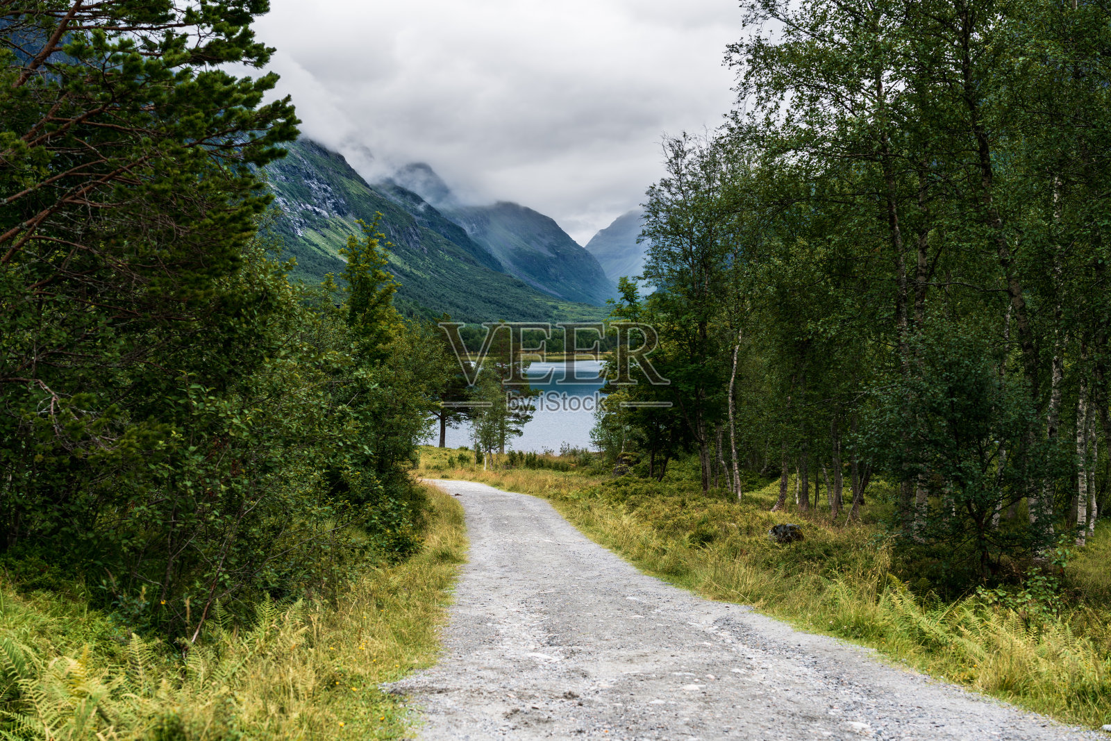 挪威特罗尔海门内尔达伦山谷中一段阴天下的砂石路照片摄影图片