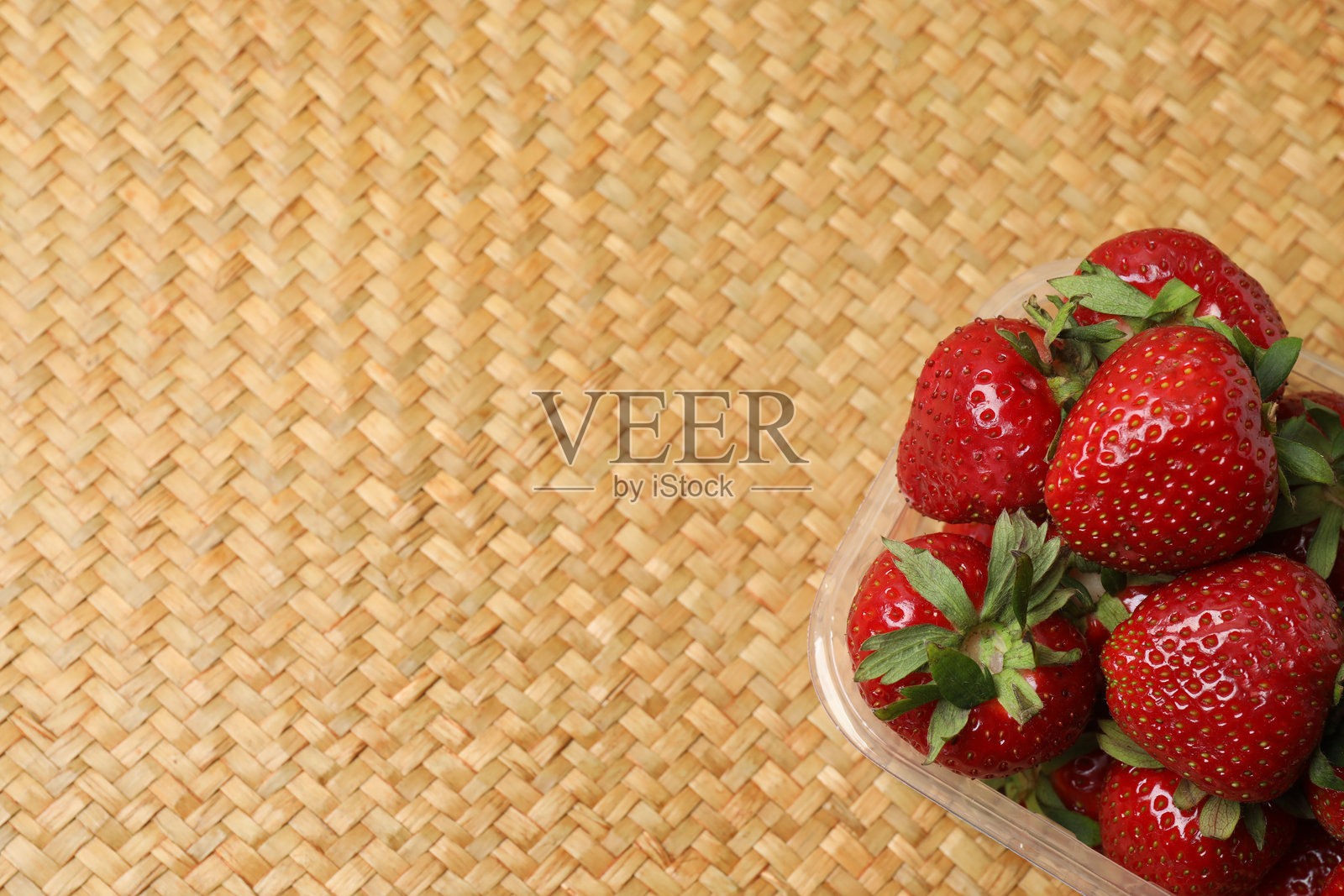 草莓放在托盘上，置于木桌之上照片摄影图片