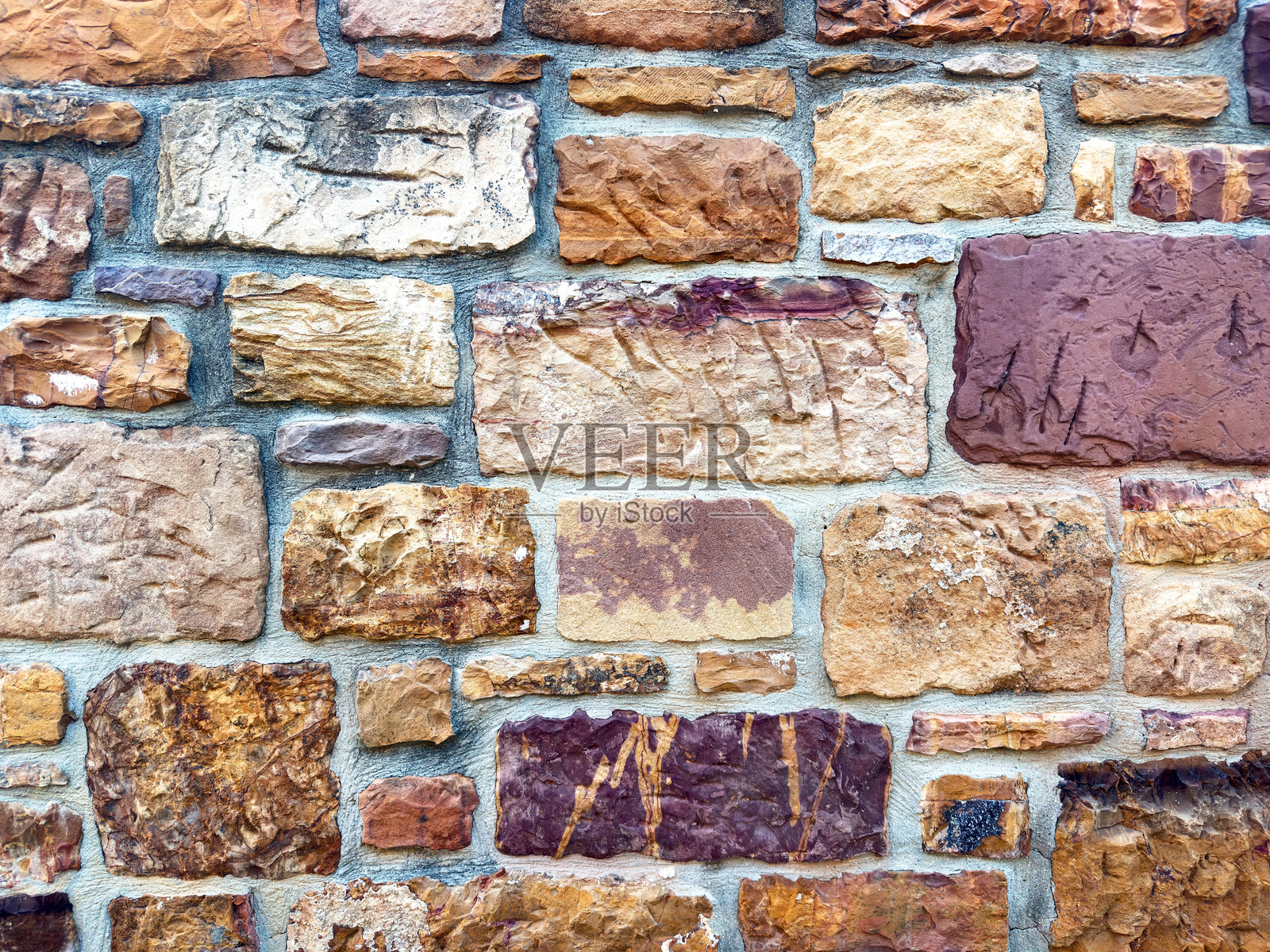 希腊希俄斯岛的传统坎波斯石墙背景，由暖红棕色的矩形石块砌成。照片摄影图片