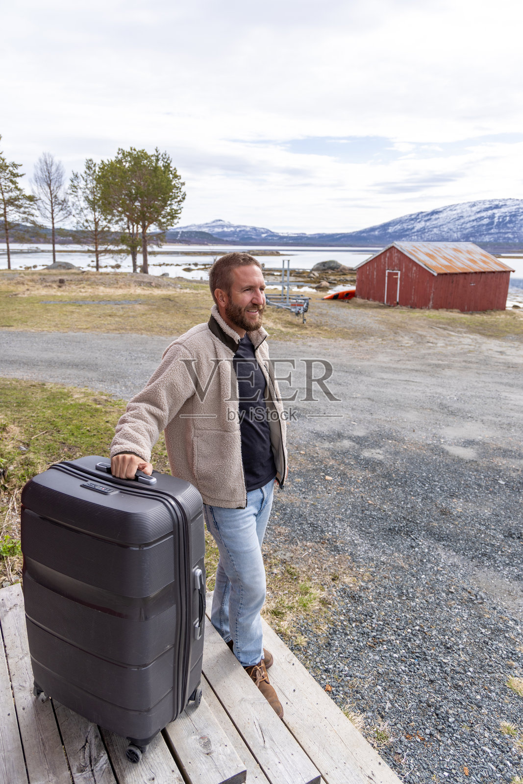 一个男人带着一个大行李箱站在户外照片摄影图片