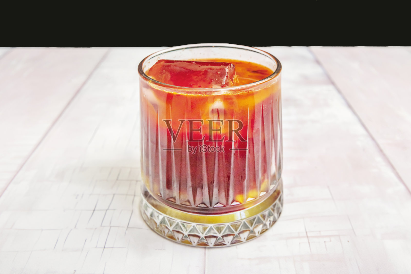 一个切割水晶玻璃杯，盛有新鲜的橙汁和咖啡，摆放在一张白色的桌子上。照片摄影图片