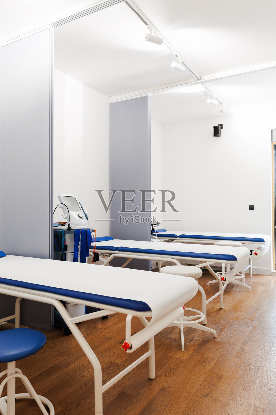现代物理治疗诊所的治疗室，配有检查床和医疗设备照片摄影图片