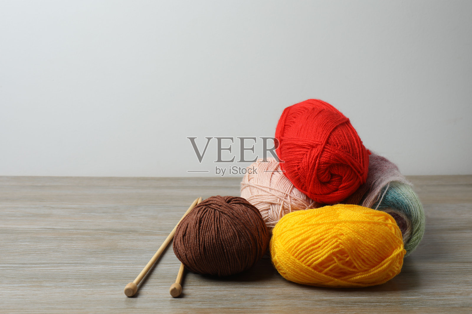 各种毛线和编织针放在木桌上，特写照片摄影图片