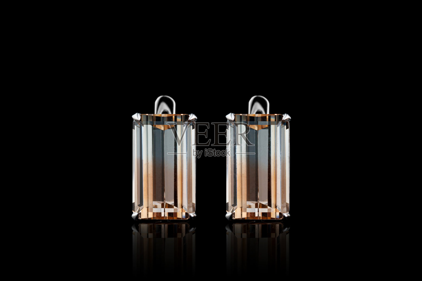 白色金属耳环，金色、银色搭配多色托帕石和钻石，背景为黑色照片摄影图片