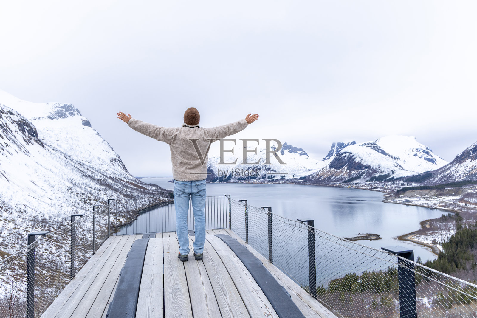 男人在雪山甲板上拥抱美景照片摄影图片