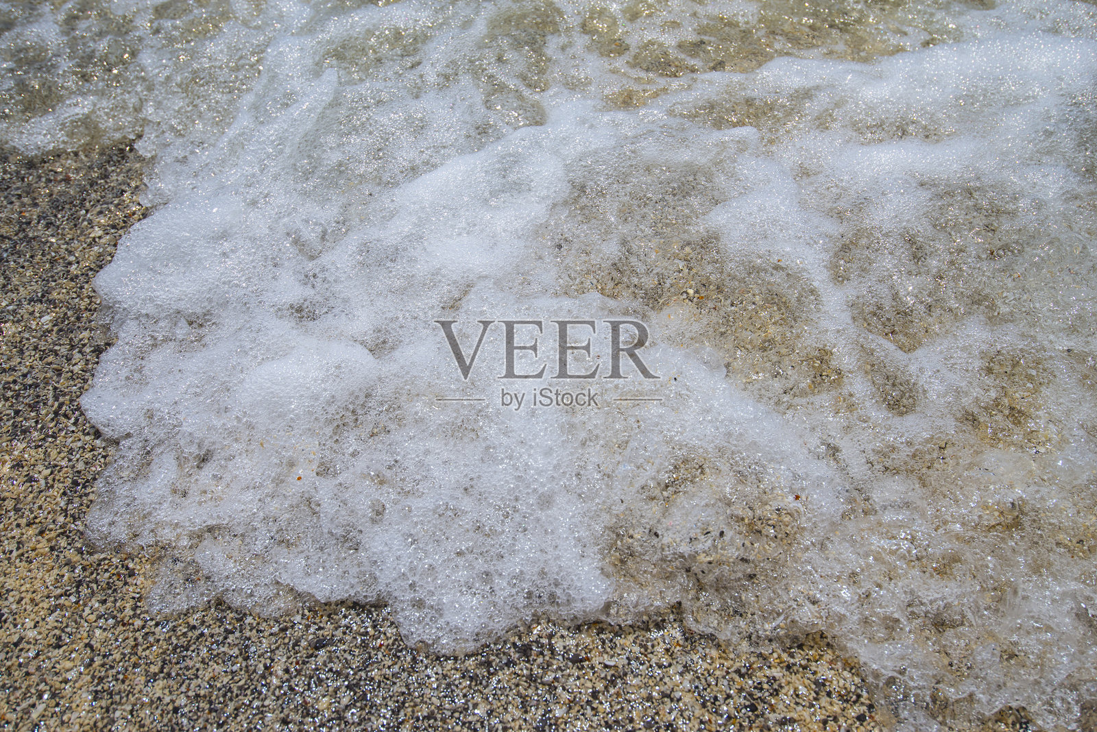 近距离拍摄海滩上的海浪与泡沫照片摄影图片