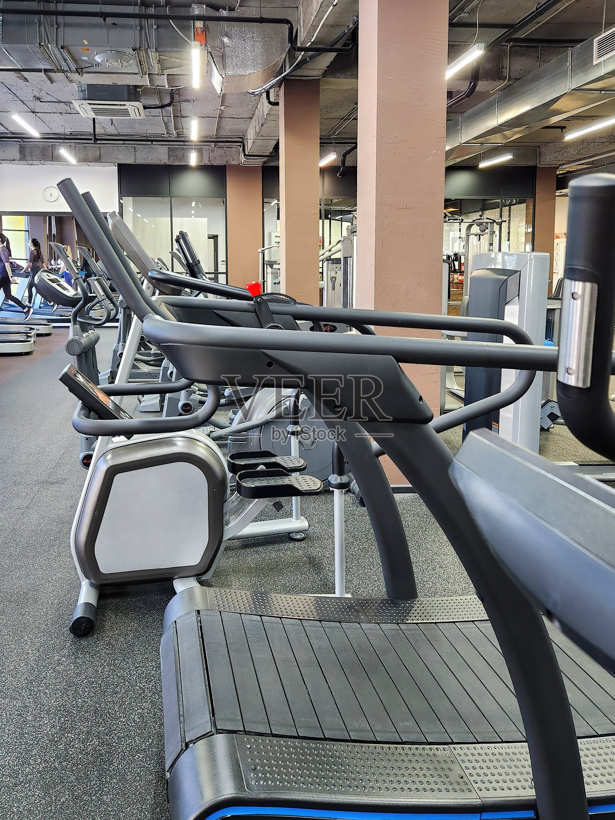 健身房里的各种跑步机。健康的生活方式照片摄影图片