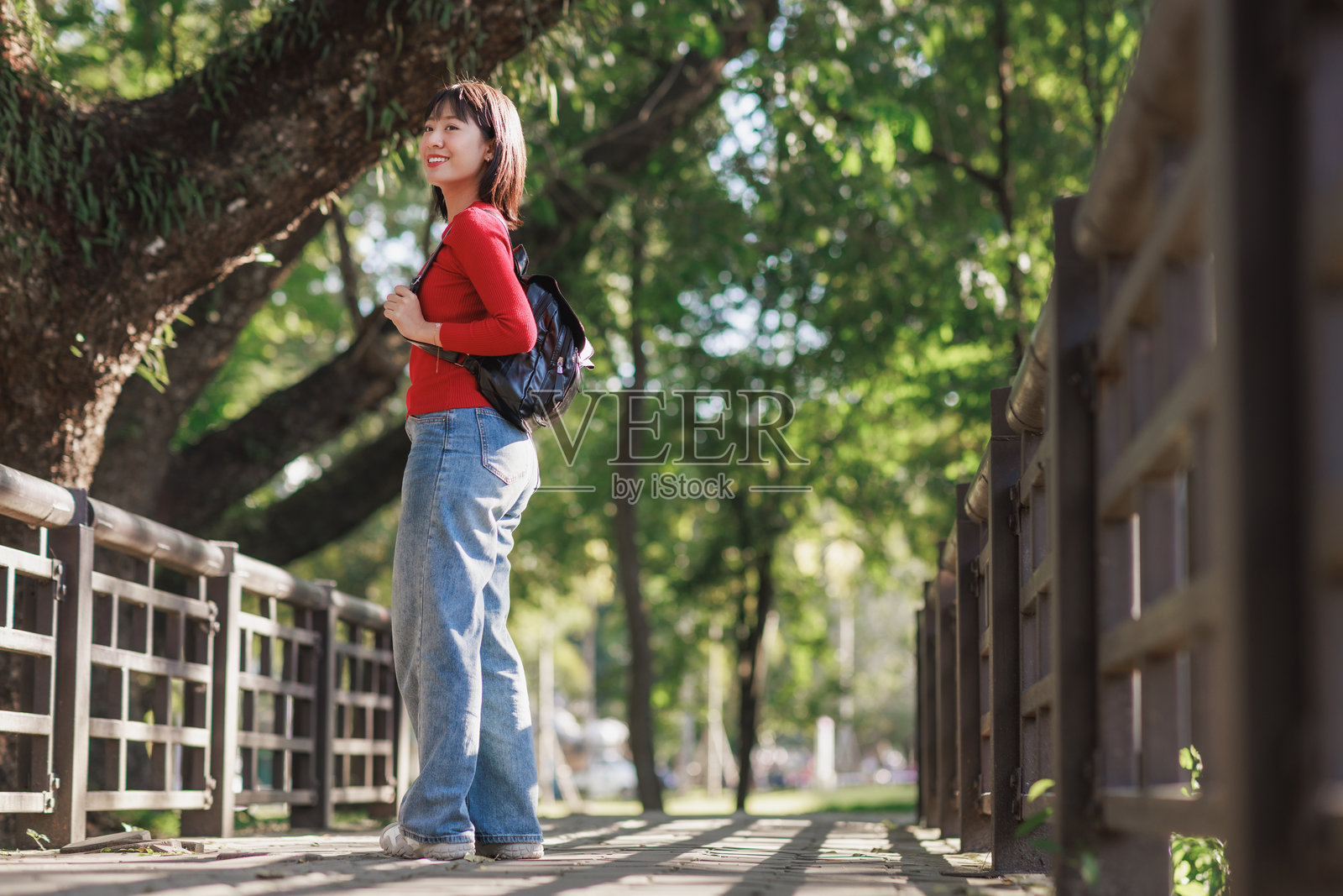 年轻亚洲女性在公园散步，享受阳光明媚的一天照片摄影图片