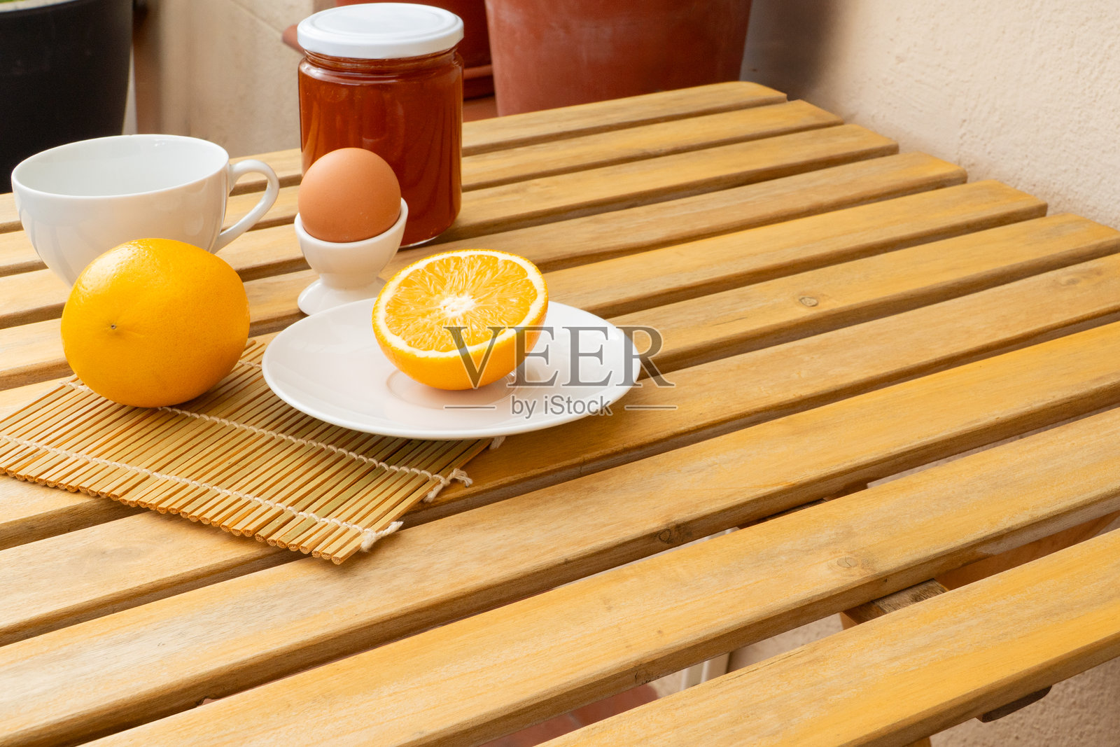 健康早餐静物：木桌上的橙子、水煮蛋和蜂蜜照片摄影图片