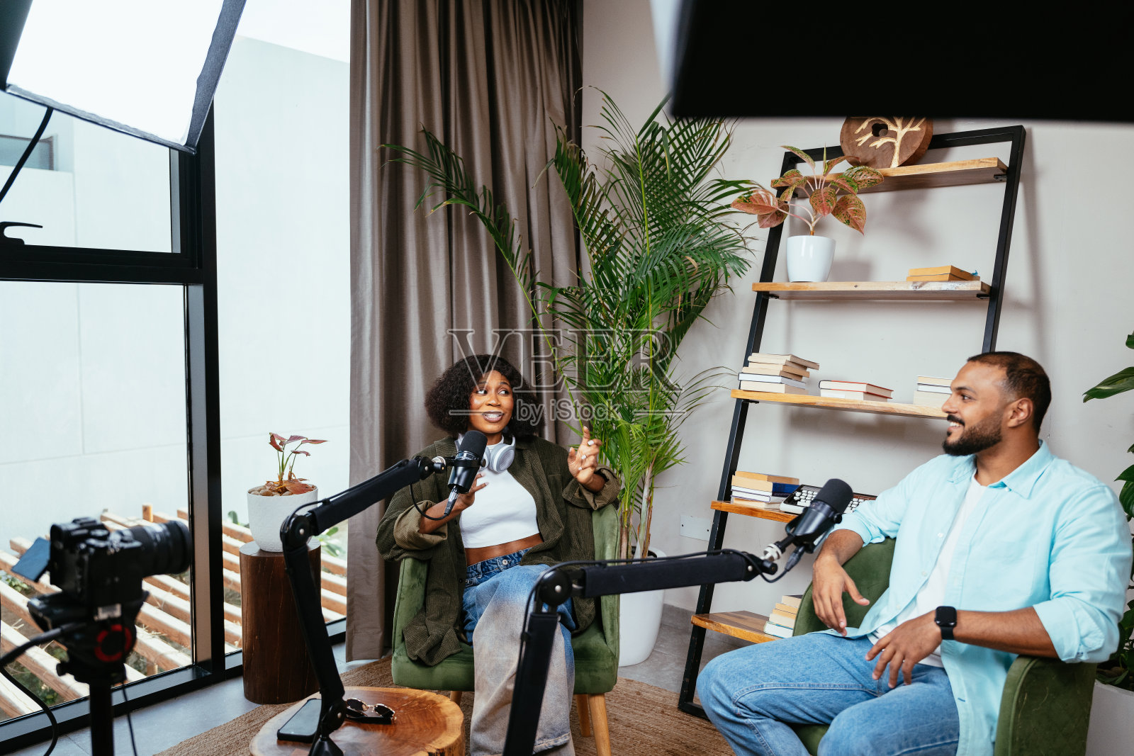 播客工作室里，一位黑人女性网红和视频博主正在与主持人进行采访照片摄影图片