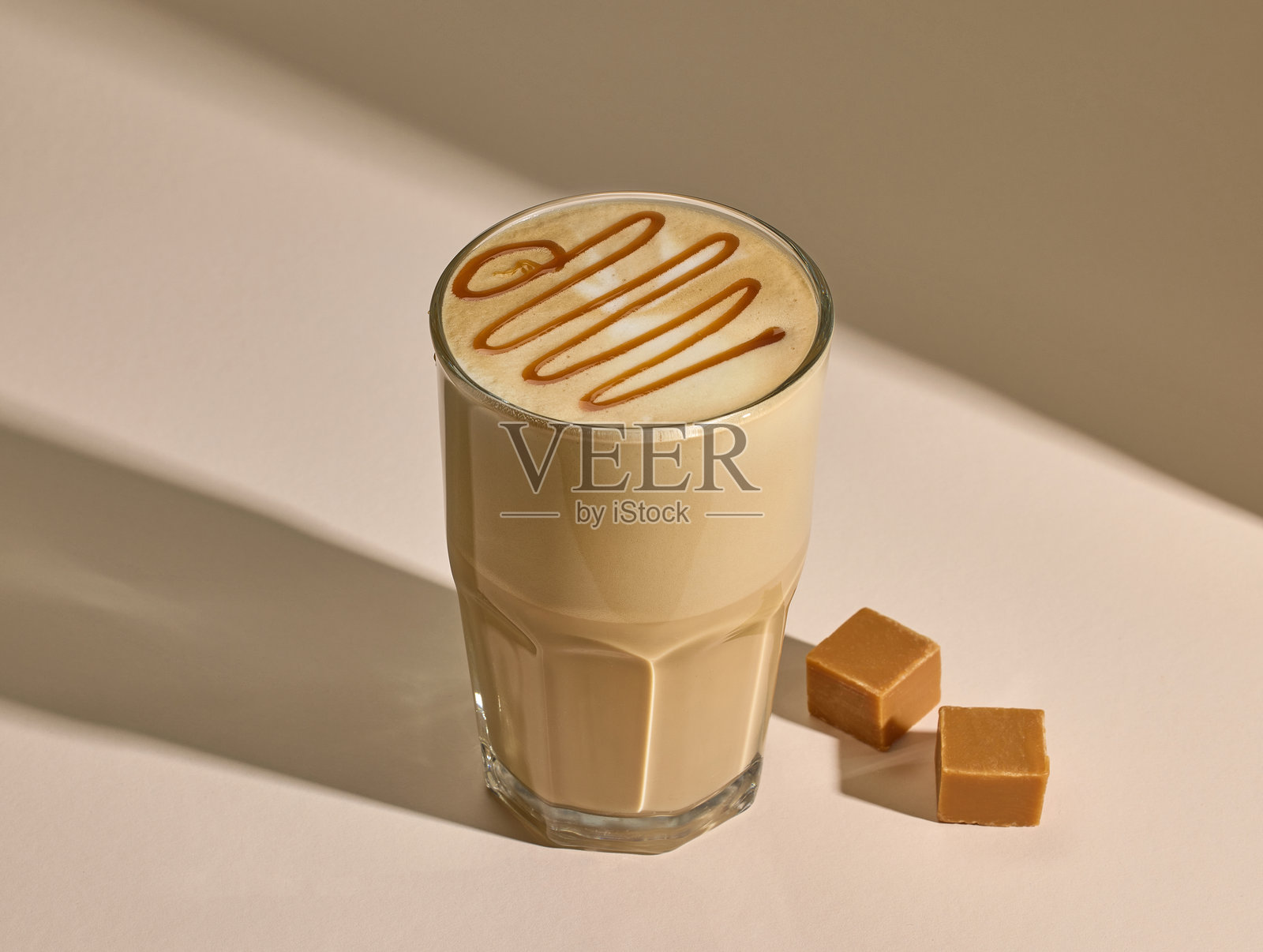 焦糖拿铁咖啡杯，背景为米色照片摄影图片