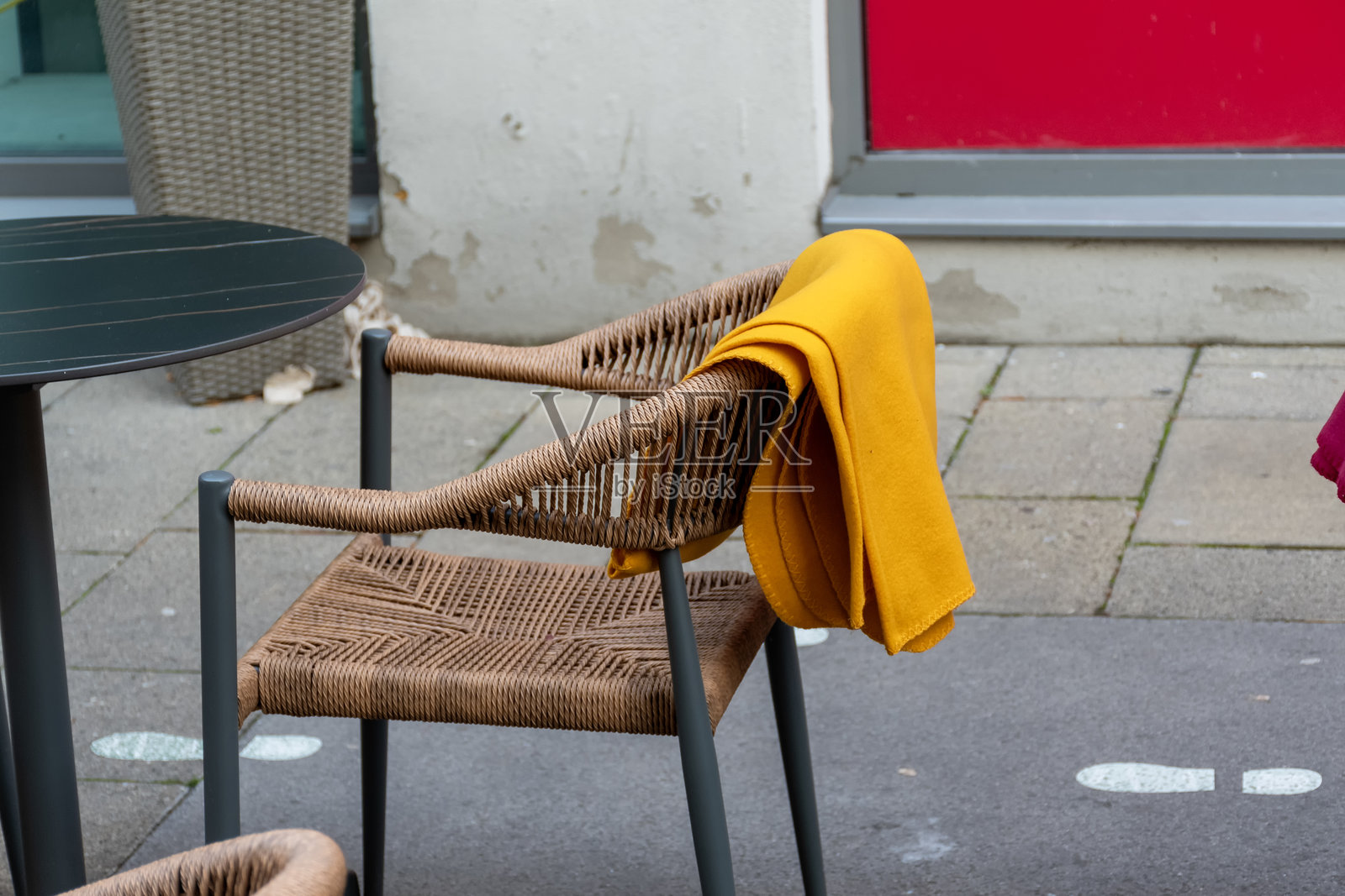 城市空间里夏日咖啡馆的柳条椅，配有鲜黄色的毯子照片摄影图片