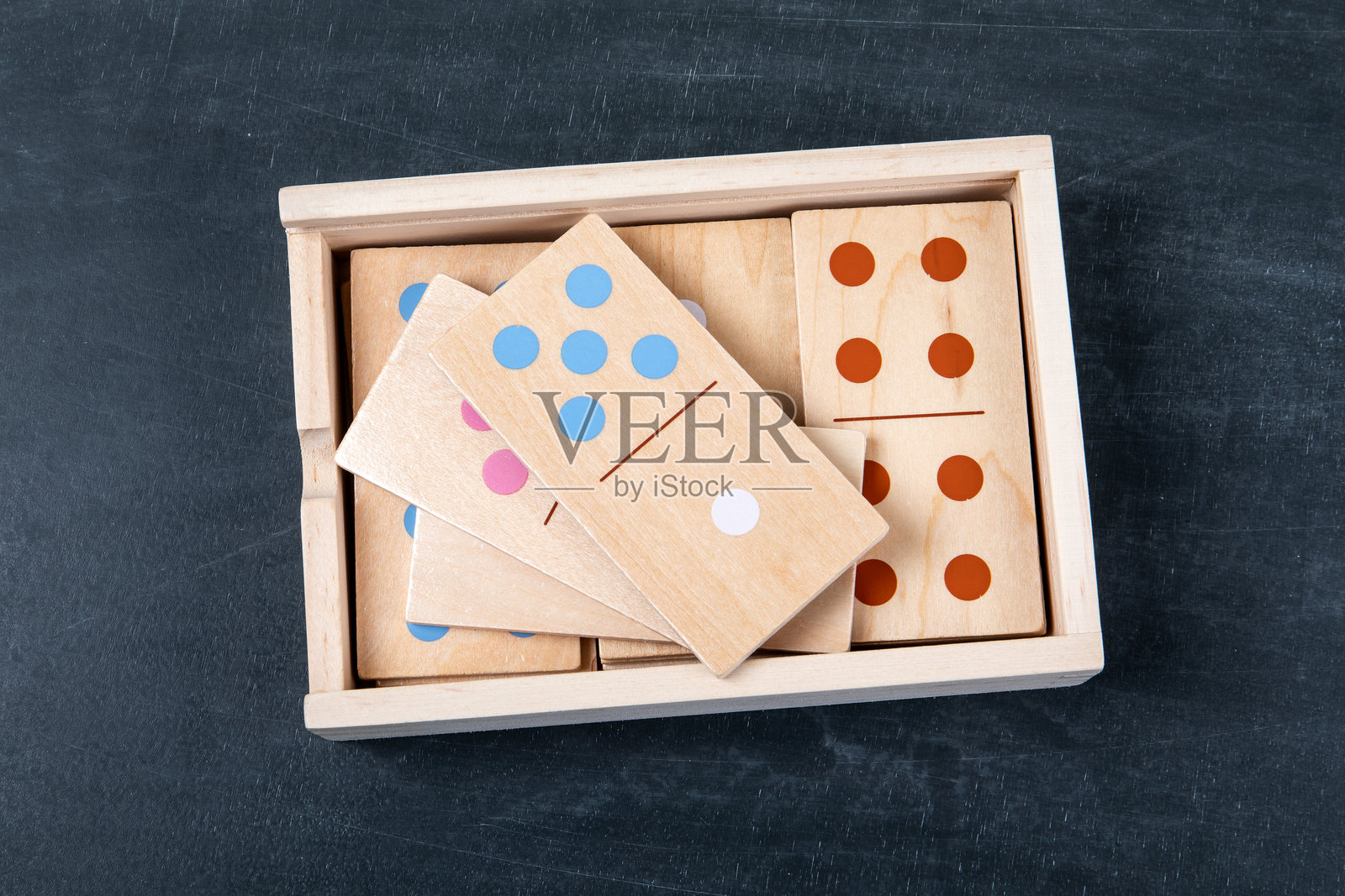深色背景下收纳在盒子里的木制多米诺骨牌照片摄影图片