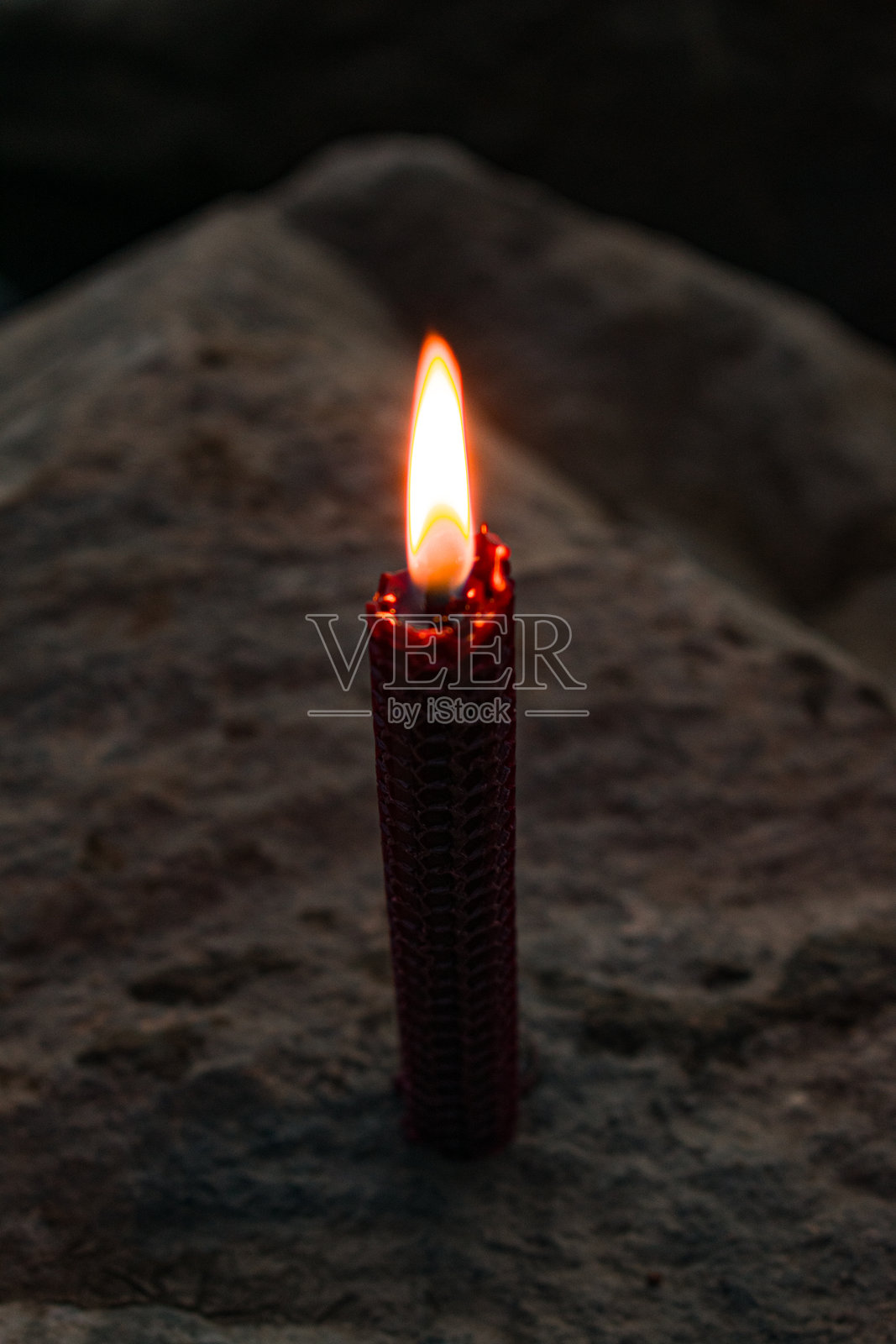 黑暗忧郁氛围中燃烧的红色蜂蜡烛火焰，微距特写照片摄影图片