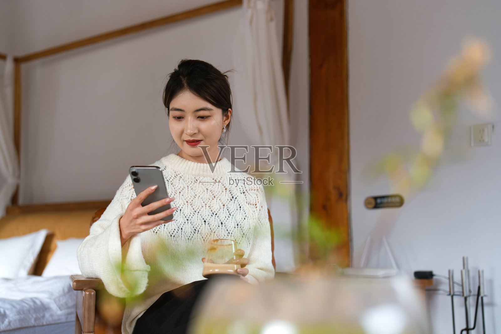 年轻女子在家坐在椅子上使用智能手机照片摄影图片