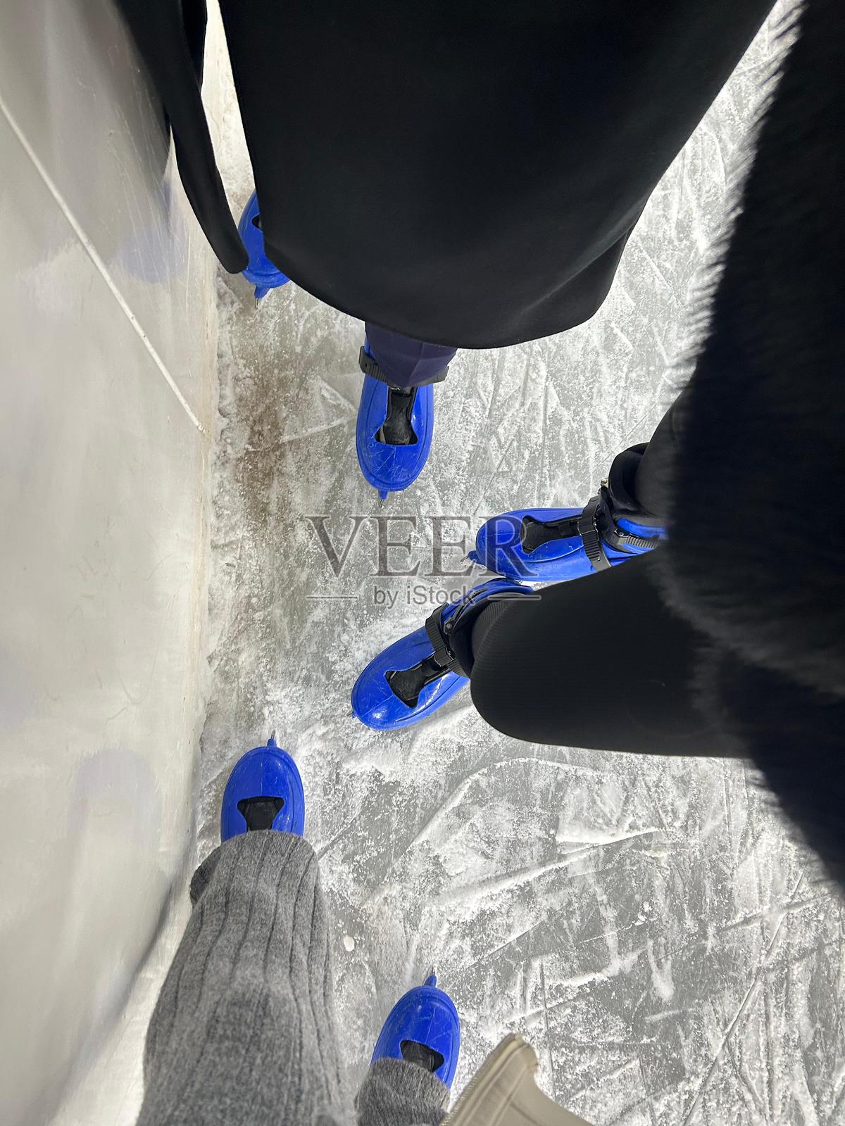 俯视着一排并排站立的人们所穿的三双冰鞋。照片摄影图片