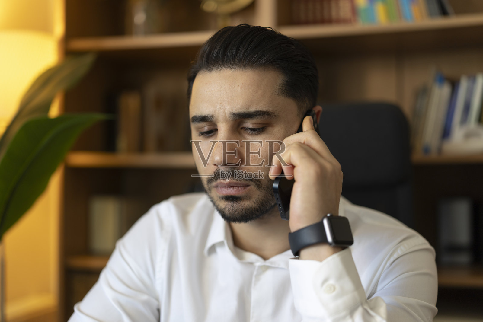 专注的男士正在打电话，手腕上戴着智能手表照片摄影图片