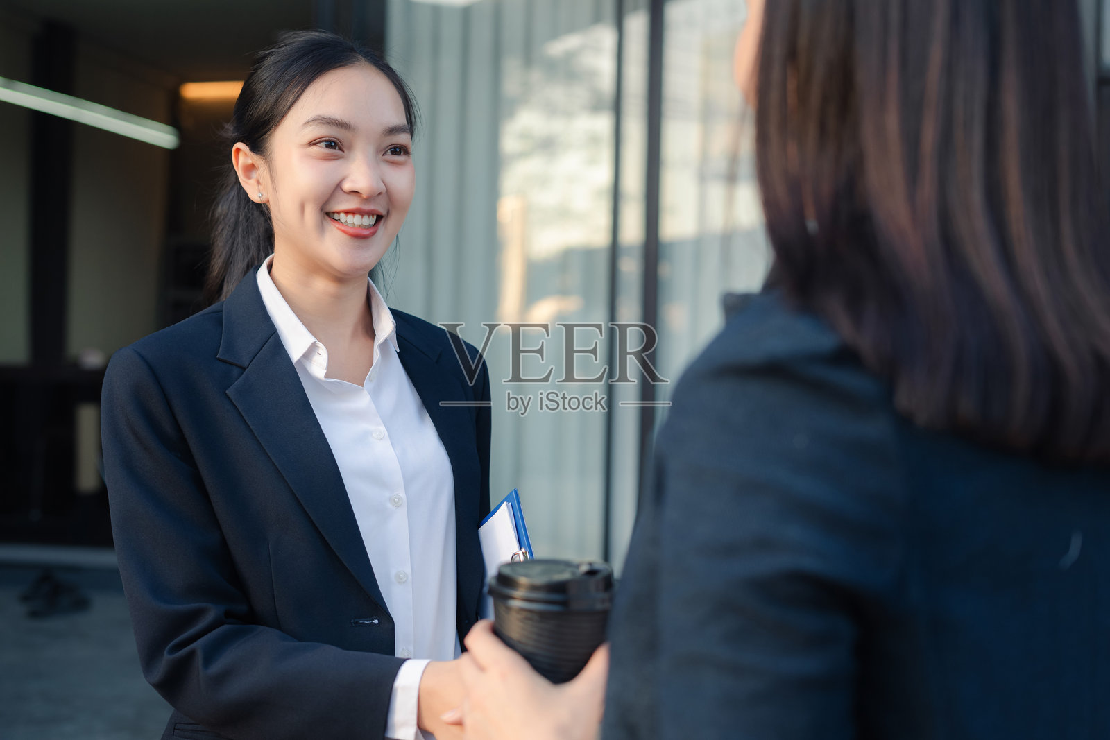 自信的商界女性握手，专业投资者在现代办公楼前与新的创业项目合作。照片摄影图片