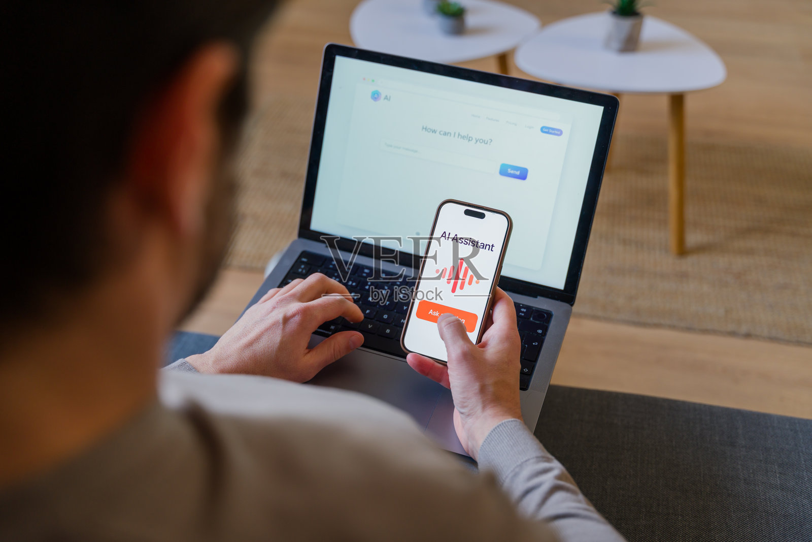 一个人正在使用带有AI助手的智能手机和笔记本电脑照片摄影图片