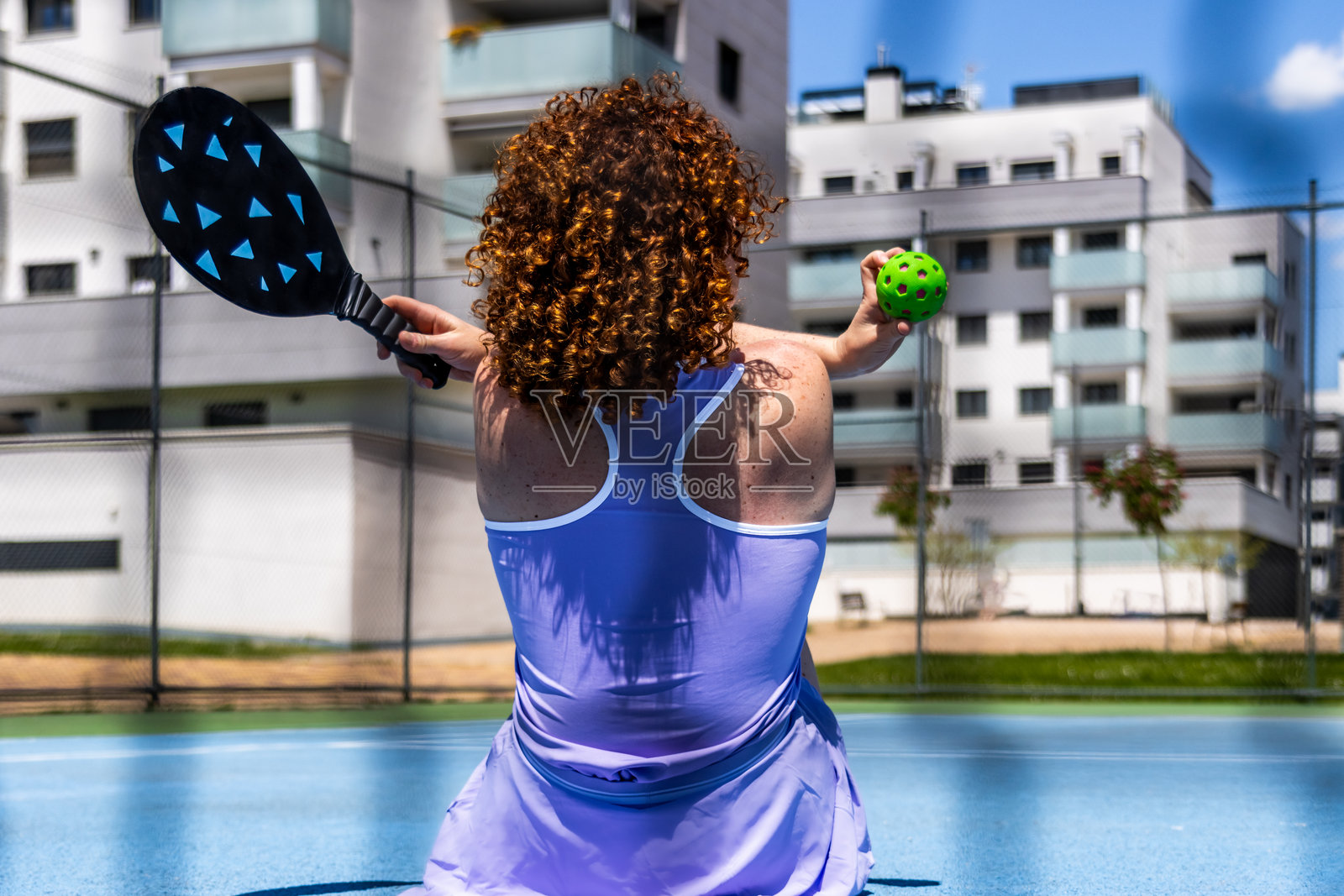 一名女子正在打匹克球，手持球拍和球照片摄影图片