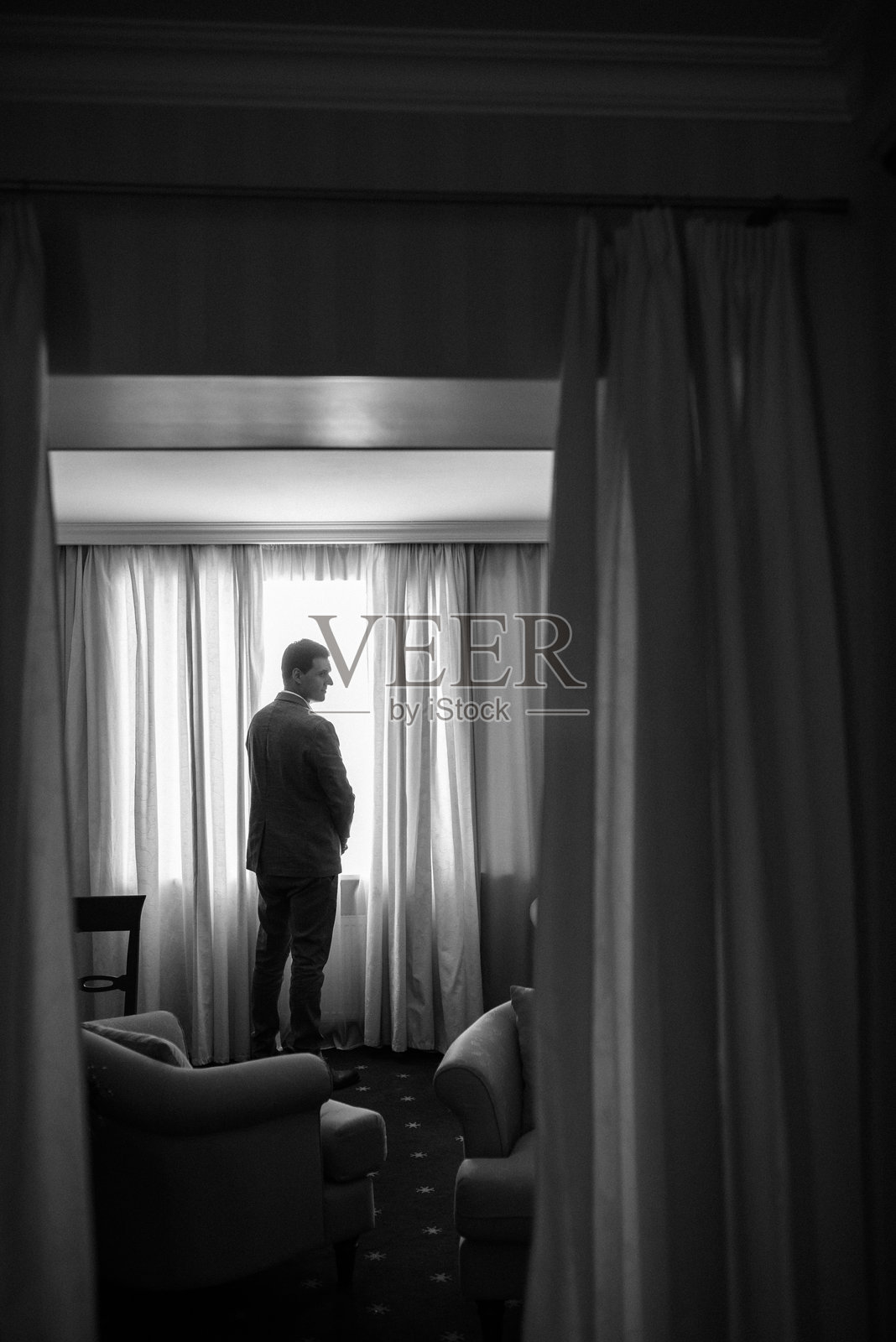 明亮工作室里，身穿蓝色夹克和白色衬衫的年轻新郎肖像照片摄影图片