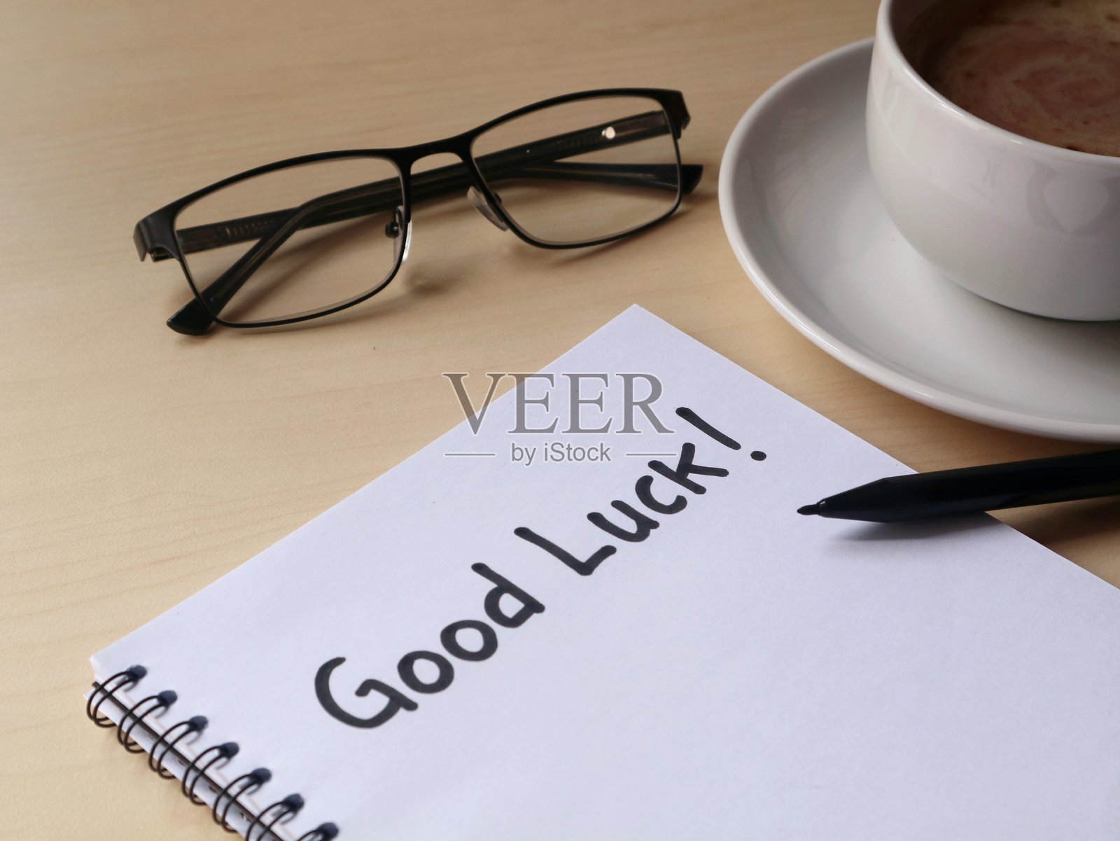 木质书桌上带有咖啡和眼镜的“祝你好运”手写留言照片摄影图片