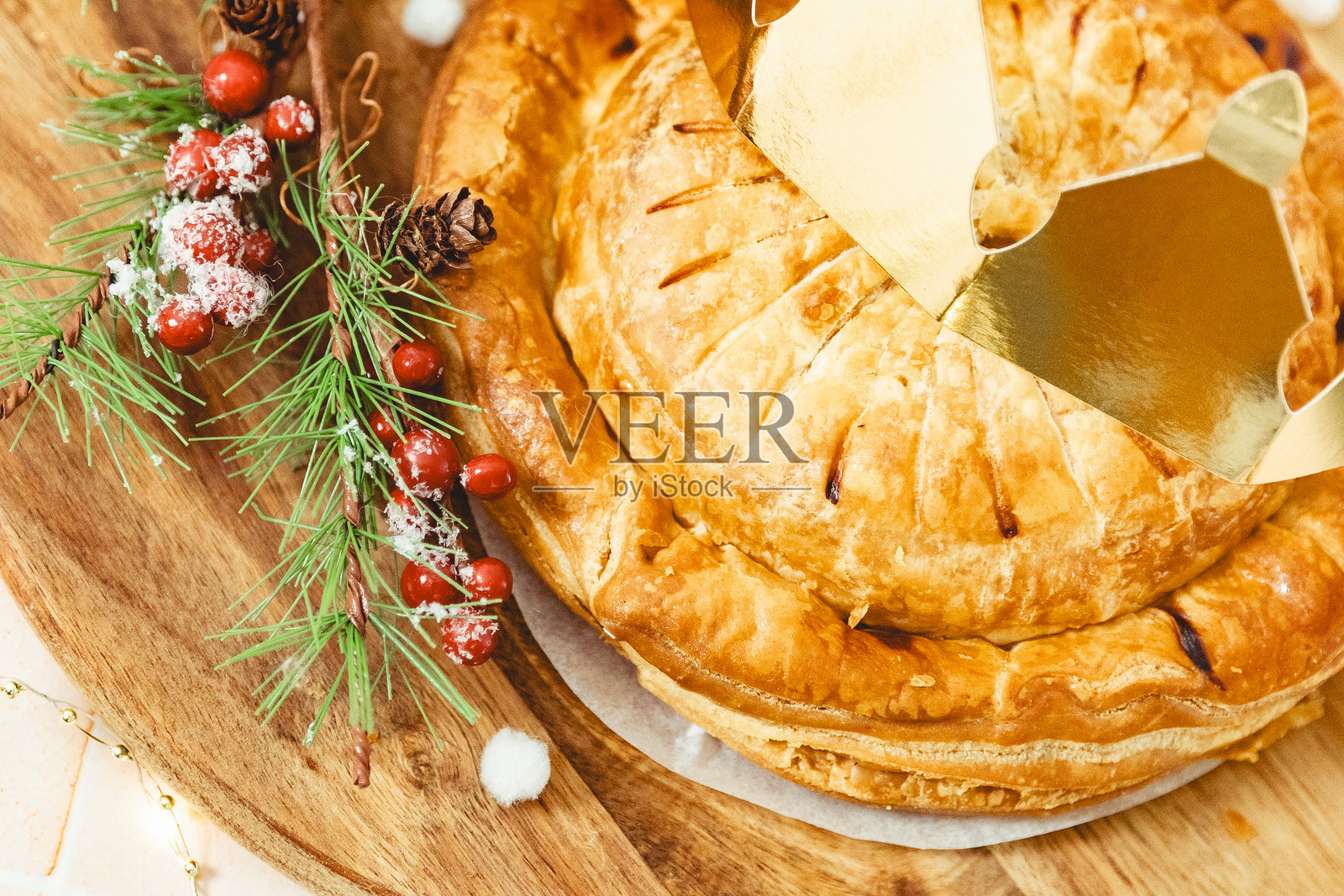 带有皇冠和装饰的千层国王饼，放在餐板上。照片摄影图片