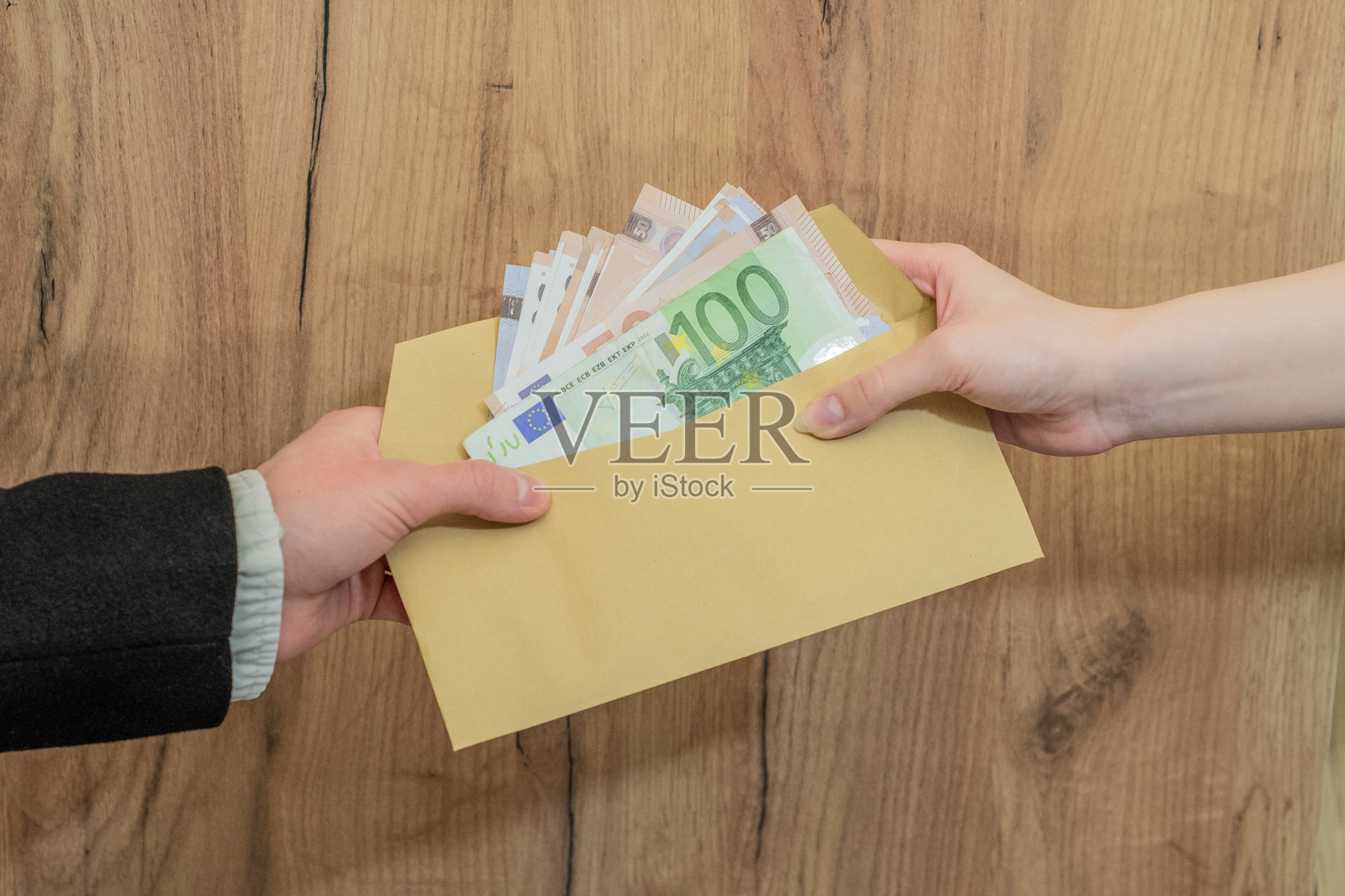 手递手递送装有欧元钞票的信封。现金照片摄影图片