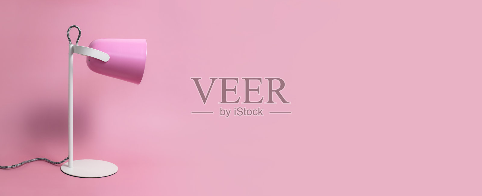 粉色背景下的现代台灯俯视平铺。灯具、台灯、灯光、室内装饰、电力。儿童粉色台灯。单一家具。金属设计师台灯。照片摄影图片