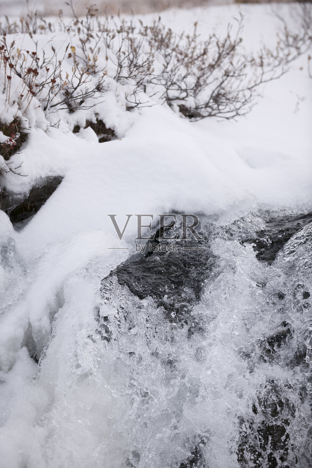 冬日山间的瀑布激起冷冽的水雾照片摄影图片