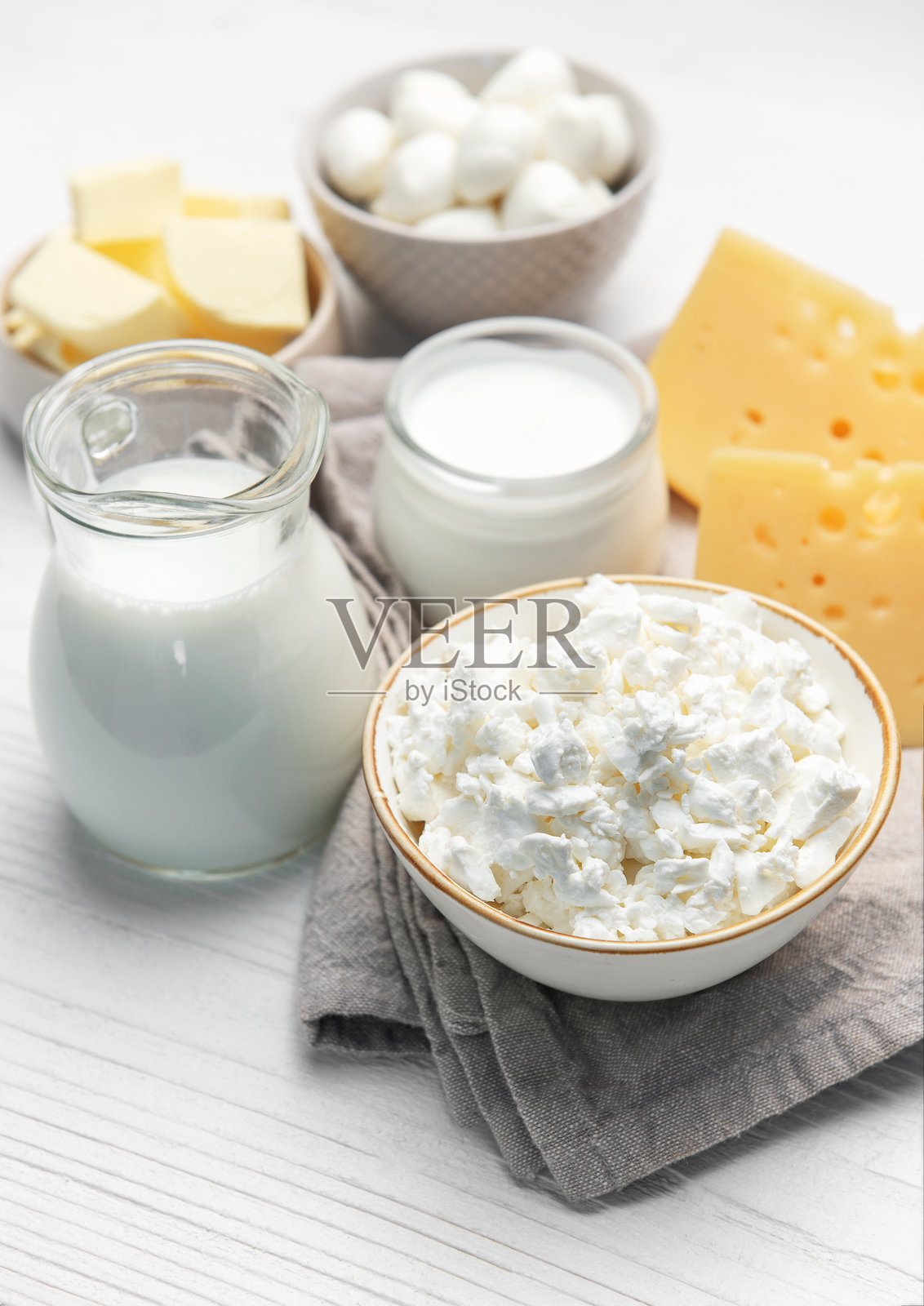 白色木桌上摆放着各式各样的新鲜乳制品照片摄影图片