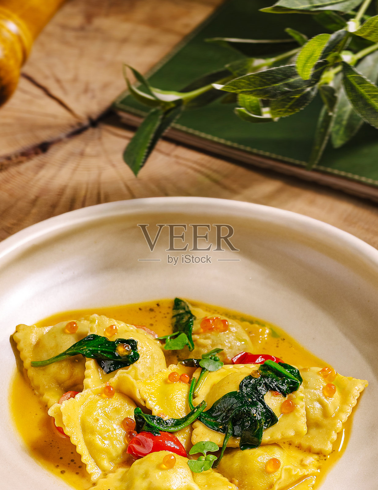 新鲜制作的意式饺子，搭配鲜艳的酱汁、蔬菜和香料照片摄影图片