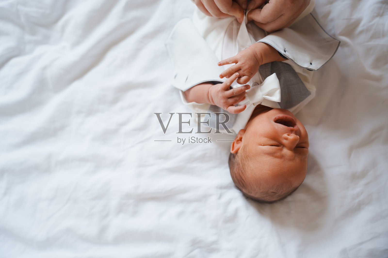 穿着正式服装的婴儿在穿衣时间享受关注照片摄影图片