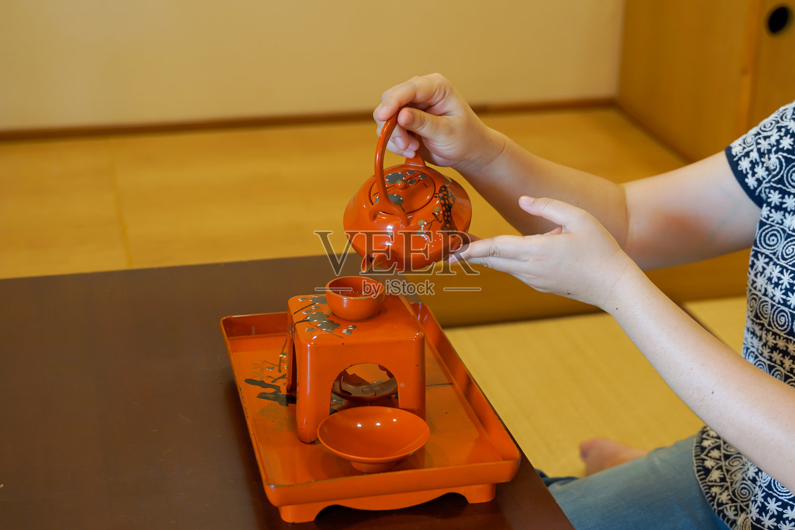 一套日式传统茶具，包括一个陶瓷茶壶和茶杯，摆放在木质托盘上，散发着禅宗文化和宁静的茶道氛围。照片摄影图片