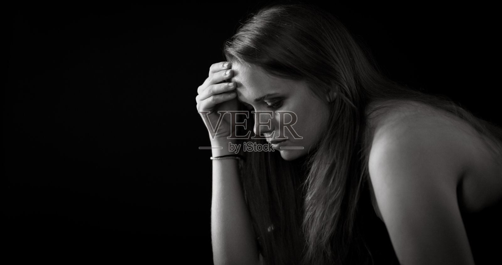 一名患有抑郁症的悲伤女子用手托着头照片摄影图片