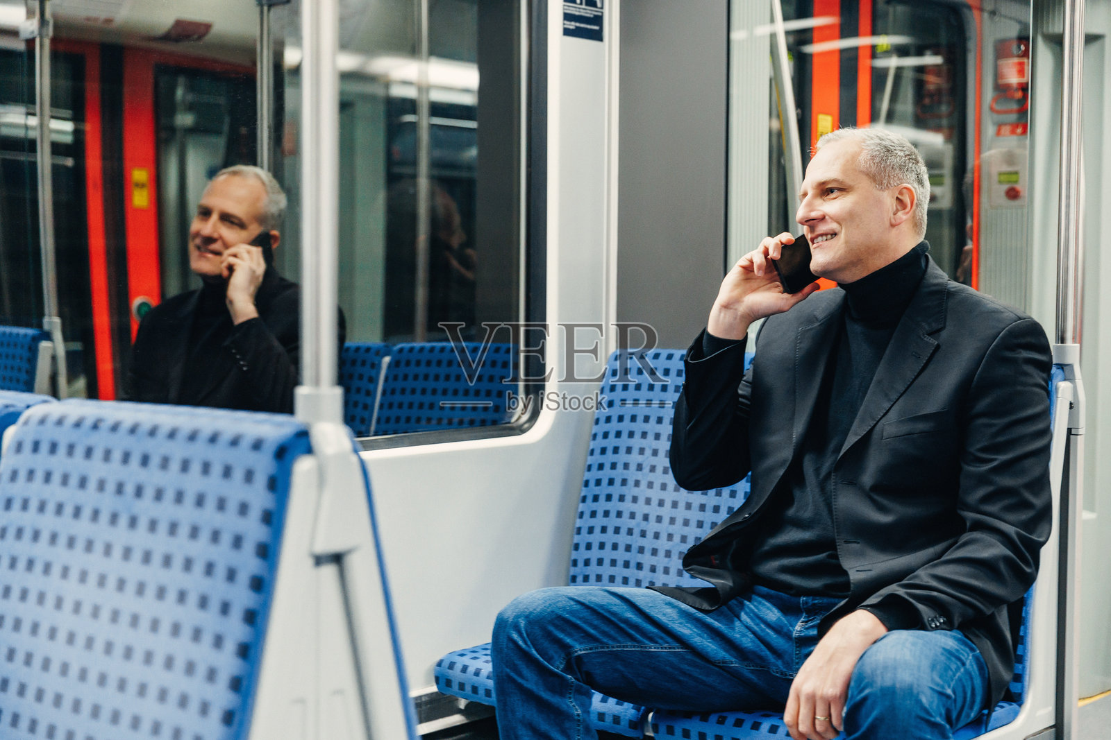 中年男子在上班途中乘坐地铁，用智能手机处理工作事宜。照片摄影图片