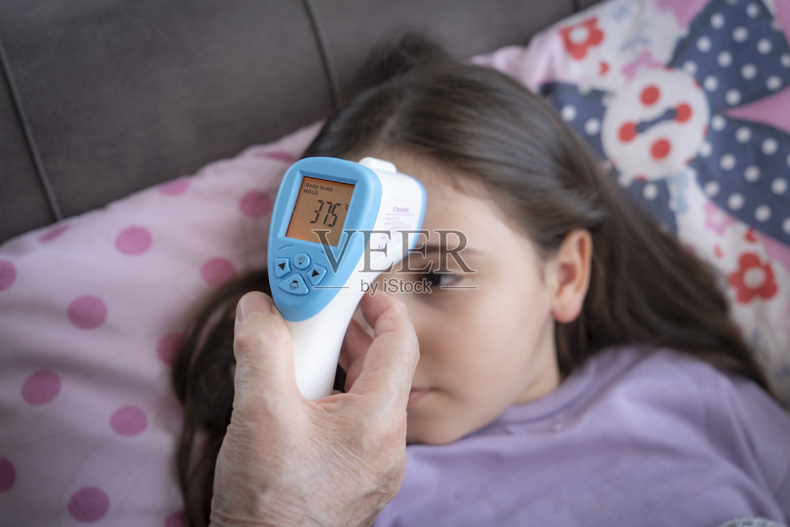 奶奶在沙发上照顾生病的孙子照片摄影图片