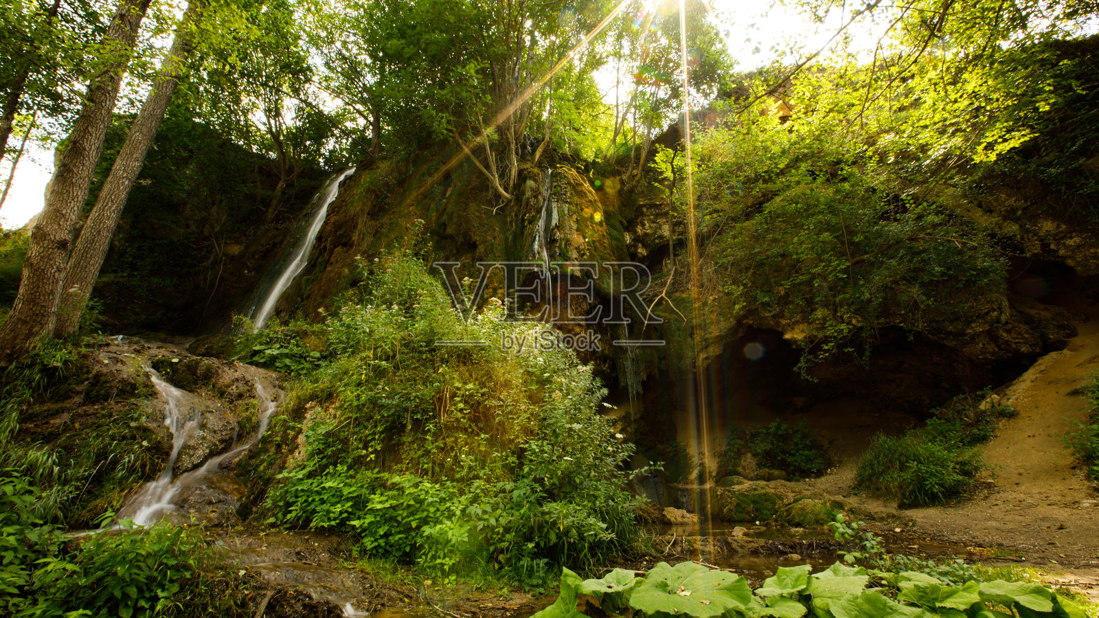 阳光明媚的森林瀑布，溪流层叠，绿意盎然，置身于宁静的自然环境中照片摄影图片