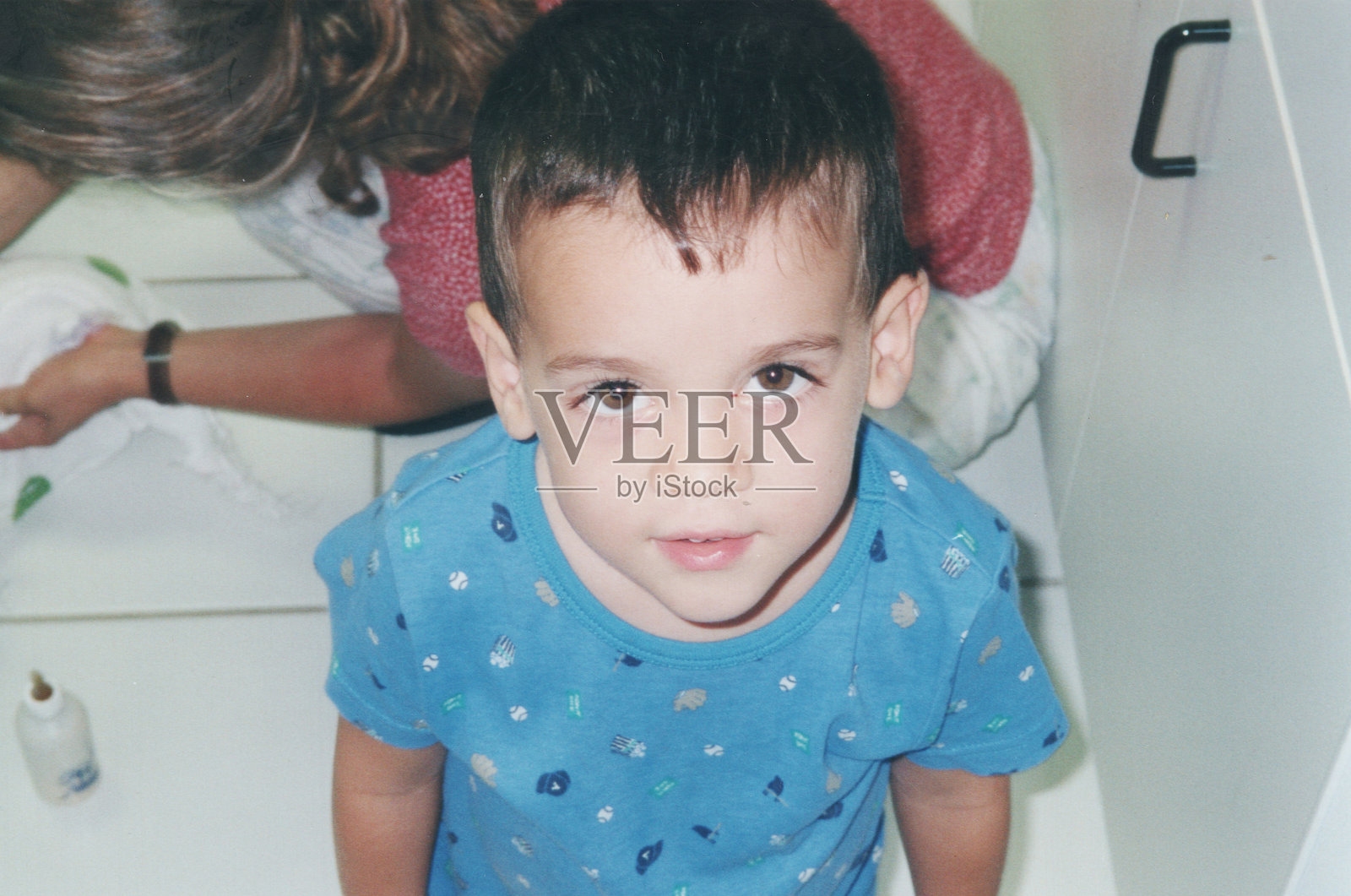 20世纪80年代拍摄：一个微笑着的小男孩在家中面向镜头摆姿势照片摄影图片