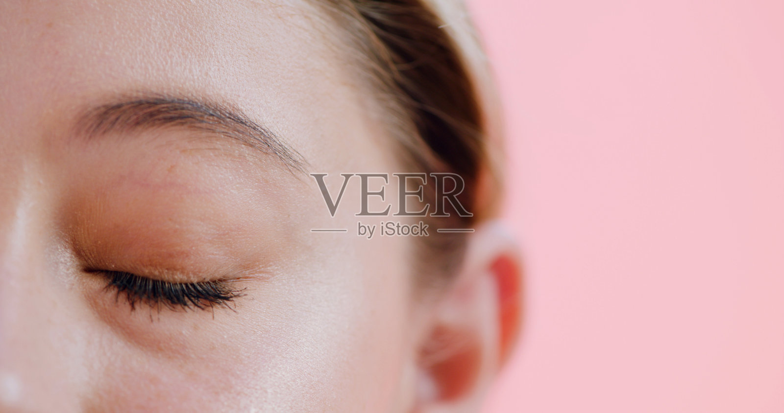 工作室里的睫毛膏、睫毛和女性，用于化妆品、丰盈和增长的眼部准备。背景为粉色，包含样机、自然妆效和睫毛提升的妆容效果。照片摄影图片