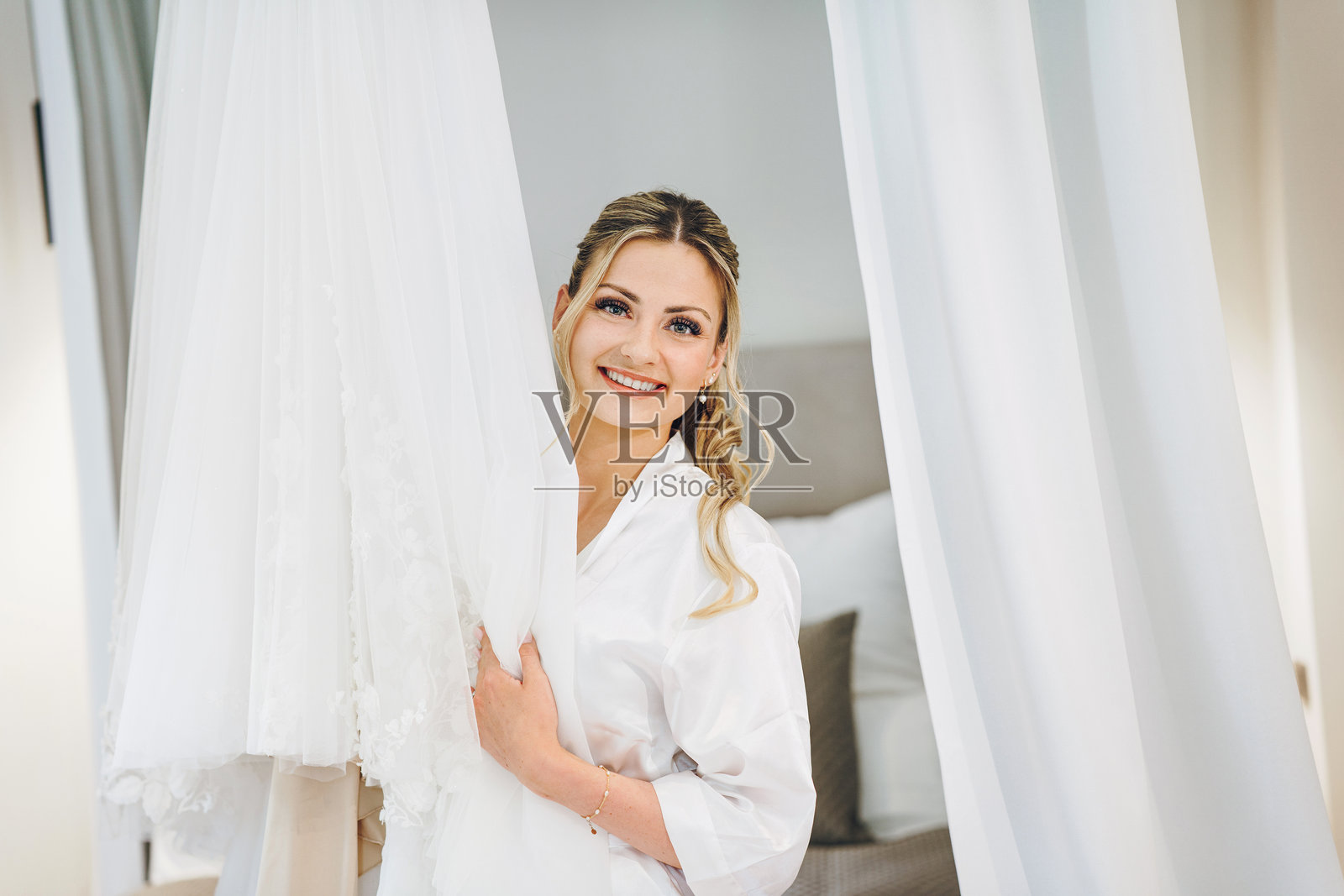 美丽的新娘正在穿婚纱，这是新婚夫妇的早晨。照片摄影图片