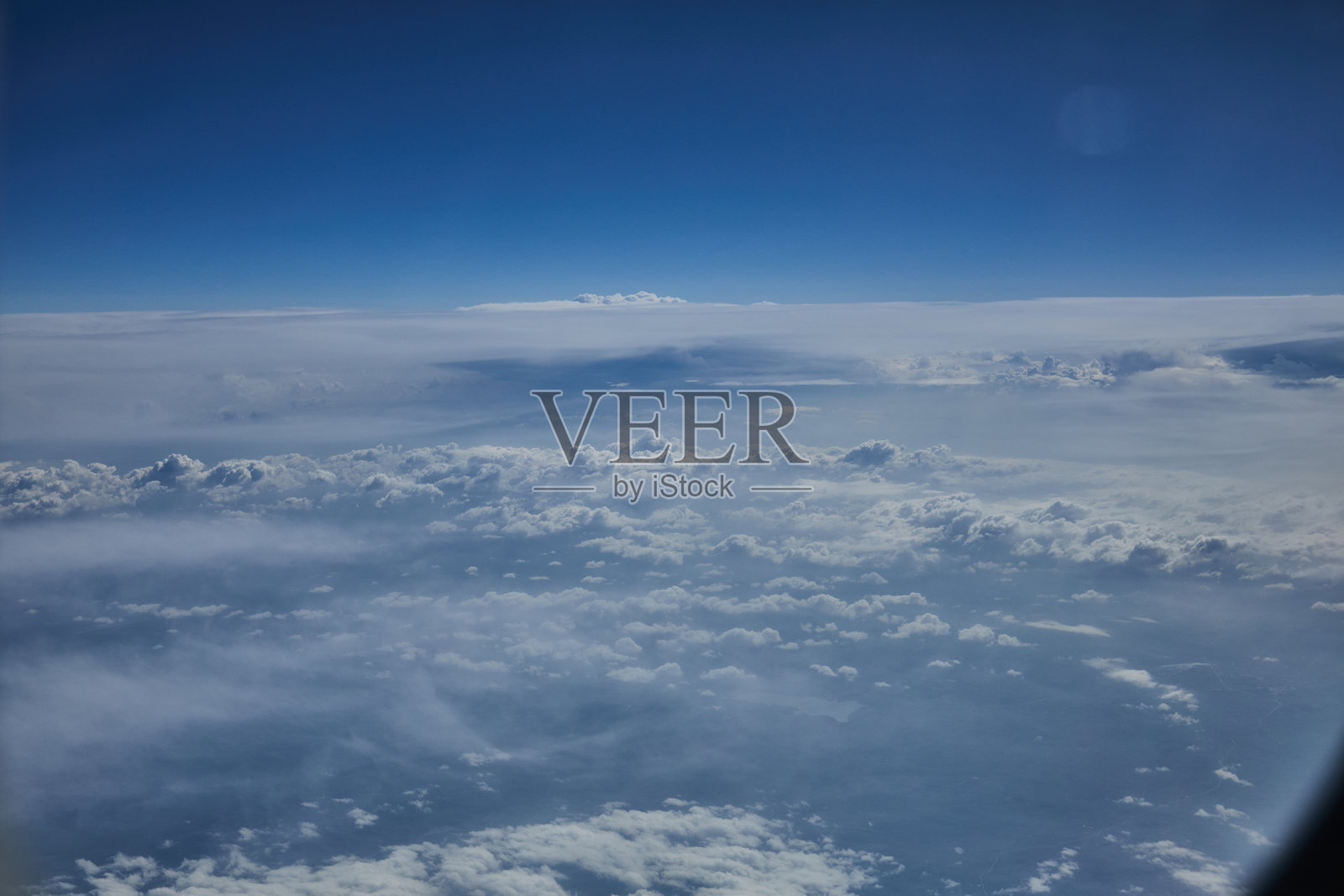 从飞机窗户俯瞰蓝天白云，宁静而广阔的景象照片摄影图片