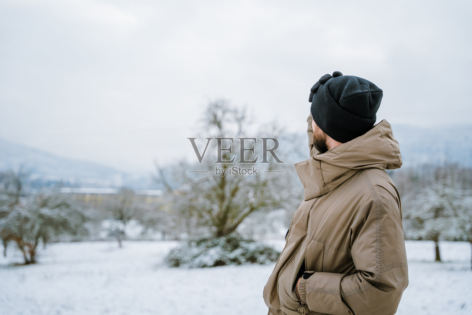 雪地公园里年轻男子的肖像。冬季概念。照片摄影图片