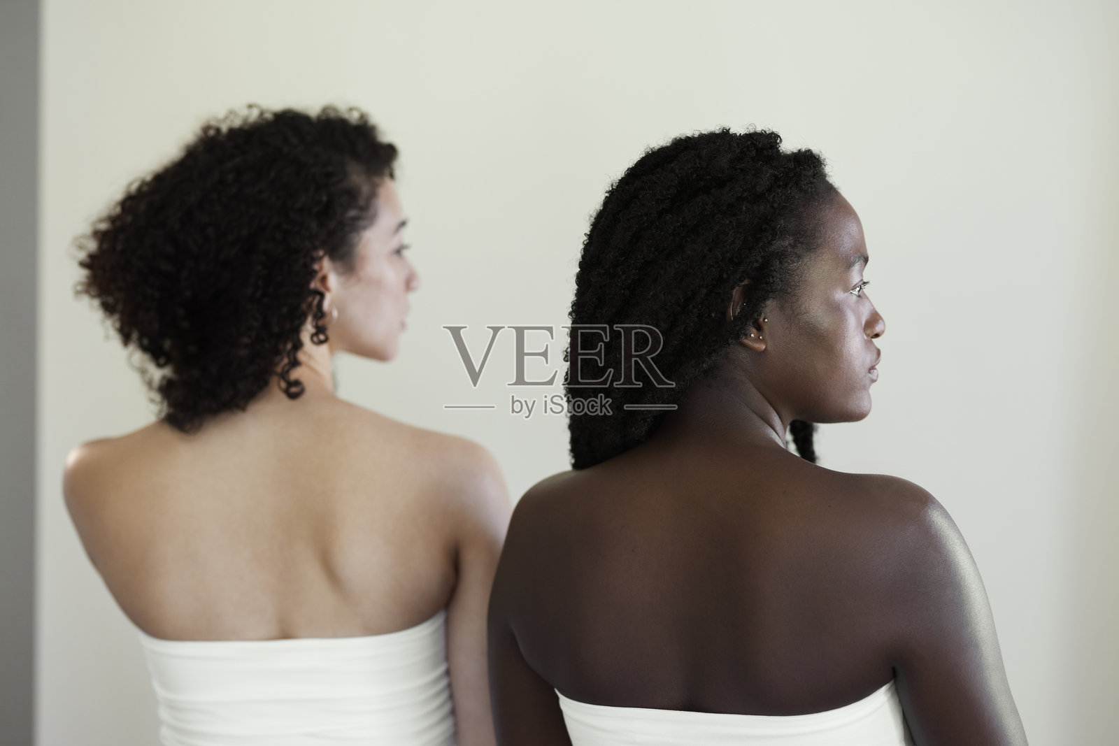 两位不同肤色的女性背影肖像，看向别处照片摄影图片